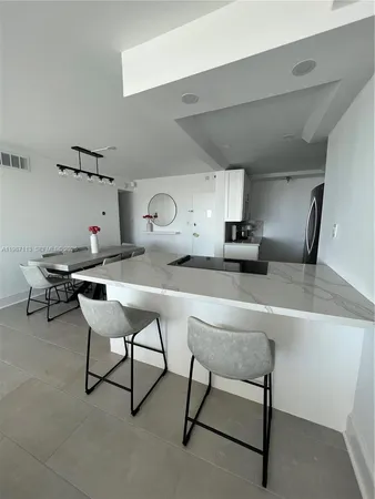 a kitchen with a table chairs and a refrigerator