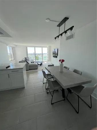 a kitchen with a table chairs and white cabinets