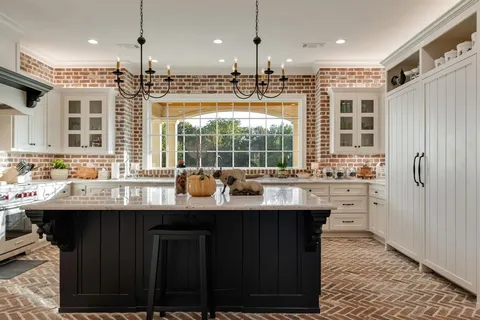 a kitchen with kitchen island granite countertop a sink appliances and cabinets