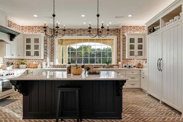 a kitchen with kitchen island granite countertop a sink appliances and cabinets