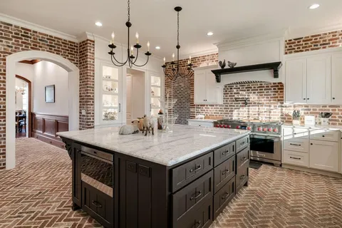 a kitchen with kitchen island granite countertop a sink a counter top space appliances and cabinets