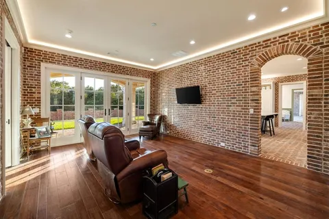 a living room with furniture floor to ceiling window and wooden floor
