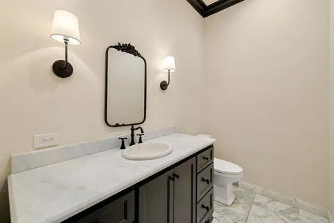 a bathroom with a sink a toilet and mirror