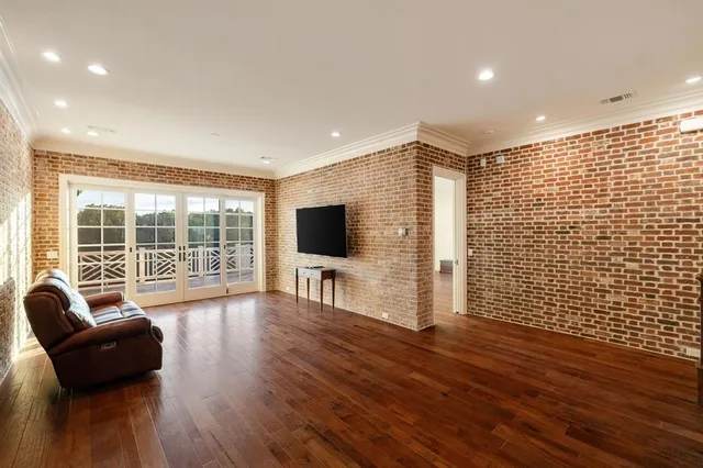 a living room with furniture floor to ceiling window and a flat screen tv
