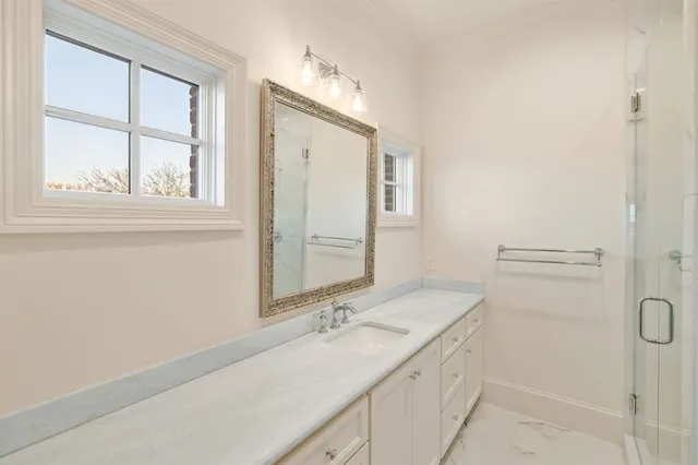 a bathroom with a granite countertop sink a mirror and a shower