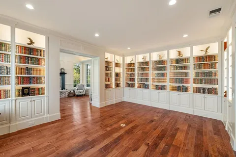 a view of empty room with wooden floor and windows