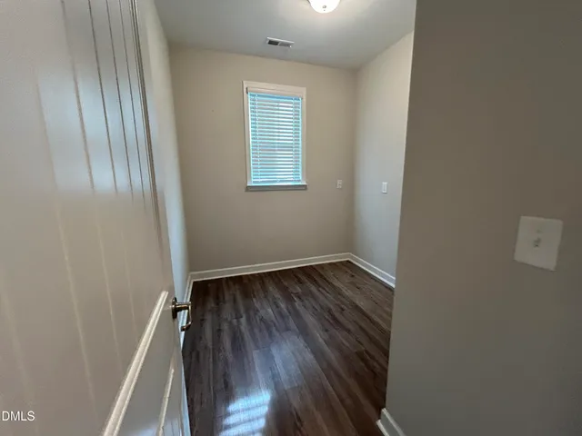 a view of a room with wooden floor and window