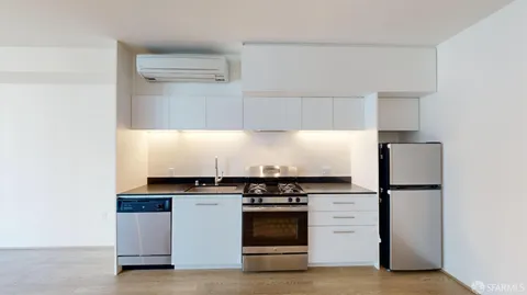 a kitchen with white cabinets and appliances
