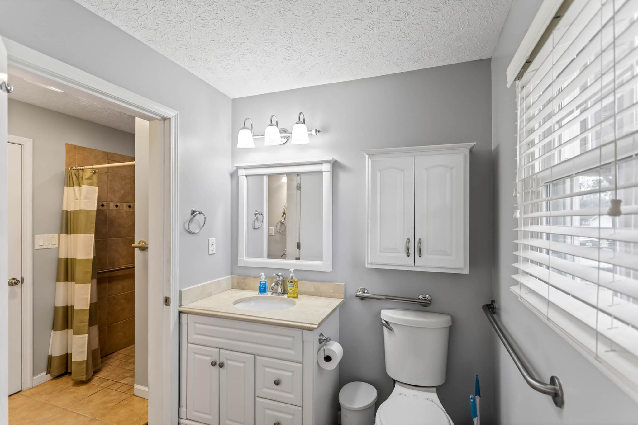 257 North Fairway Road Franklin, KY 42134 - Photo 21 of 30 a bathroom with a toilet a sink a mirror a window and vanity