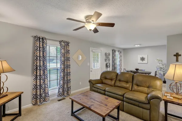 a living room with furniture and a chandelier