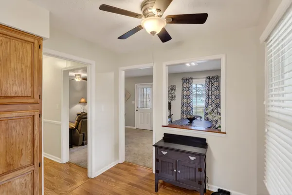 a view of a hallway with bathroom and wooden floor