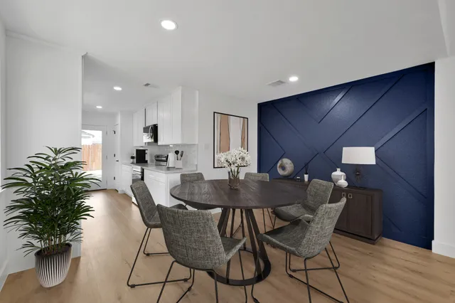 a dining room with furniture and potted plants