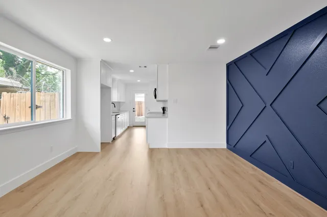 a view of a big room with wooden floor and windows
