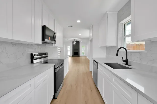 a kitchen with stainless steel appliances granite countertop a sink stove and refrigerator