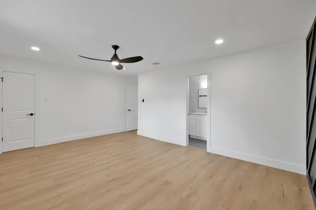 a view of a livingroom with a ceiling fan and wooden floor