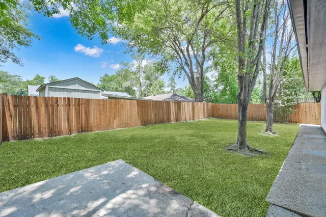 a view of a backyard with wooden fence