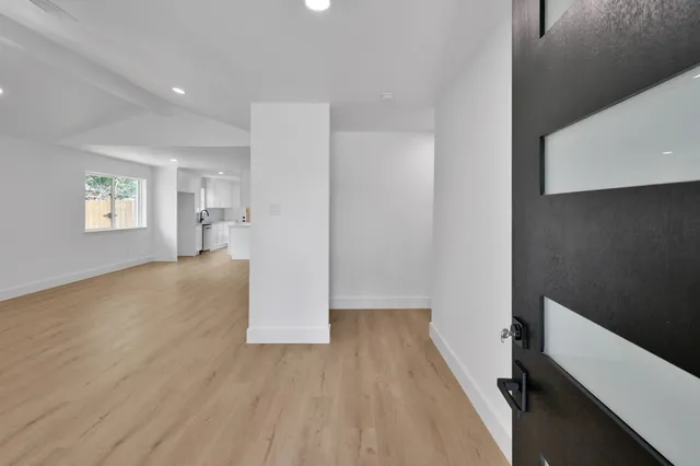 a view of empty room with wooden floor