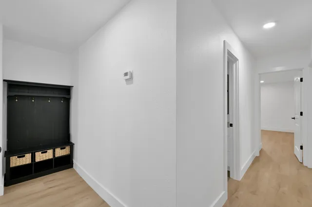 a view of a hallway with wooden floor and staircase