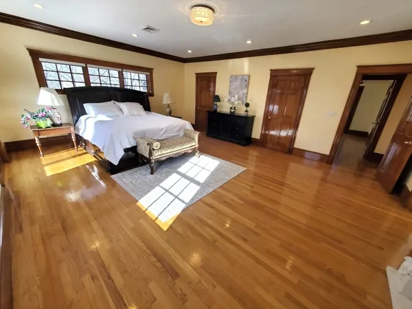 a dining room with wooden floor and chandelier