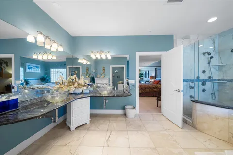 a spacious bathroom with a granite countertop sink a mirror and a bathtub