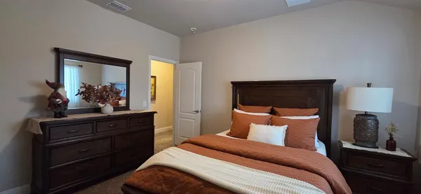 a bedroom with a bed and a mirror on dresser