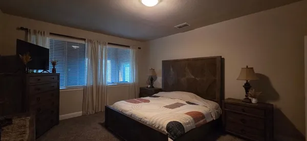 a bedroom with a bed and a flat tv screen