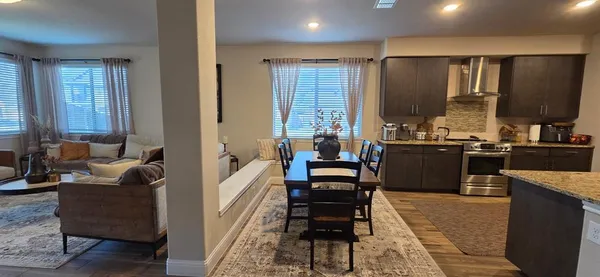 a large living room with stainless steel appliances kitchen island granite countertop furniture and a window