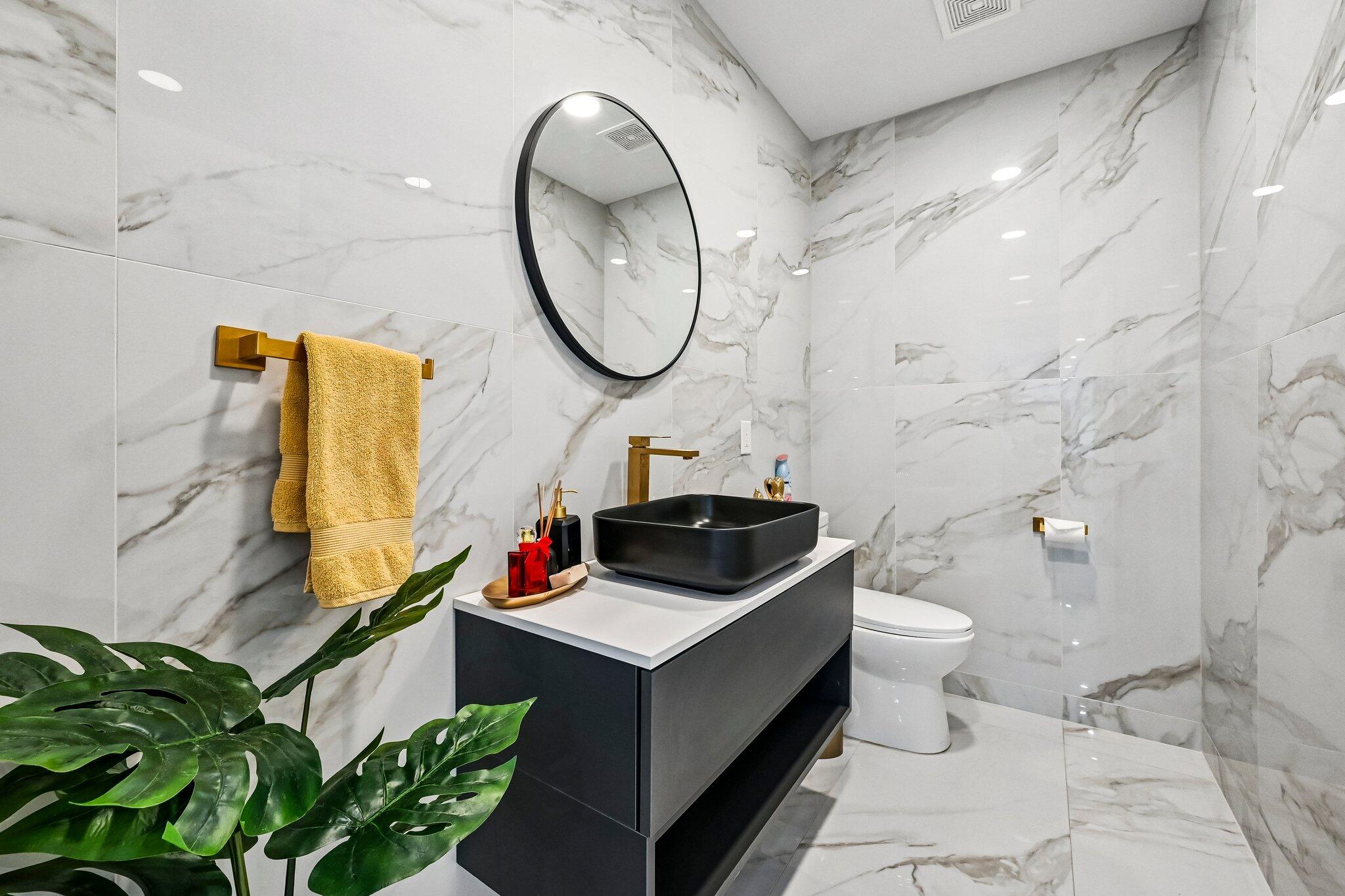 2940 Northeast 39th Court Lighthouse Point, FL 33064 - Photo 23 of 42 a bathroom with a sink a toilet and a mirror