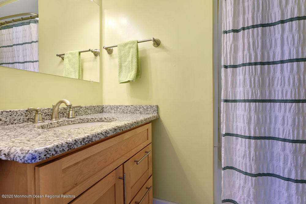 292 N Street, Unit A1 Seaside Park, NJ 08752 - Photo 12 of 31 a bathroom with a granite countertop sink and a mirror