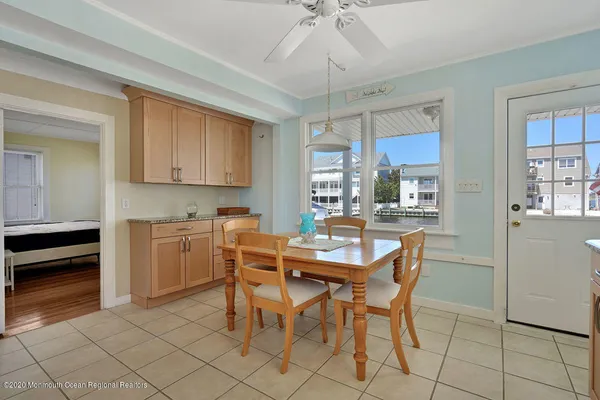 a kitchen with stainless steel appliances granite countertop a stove a refrigerator a sink a dining table and chairs with wooden floor