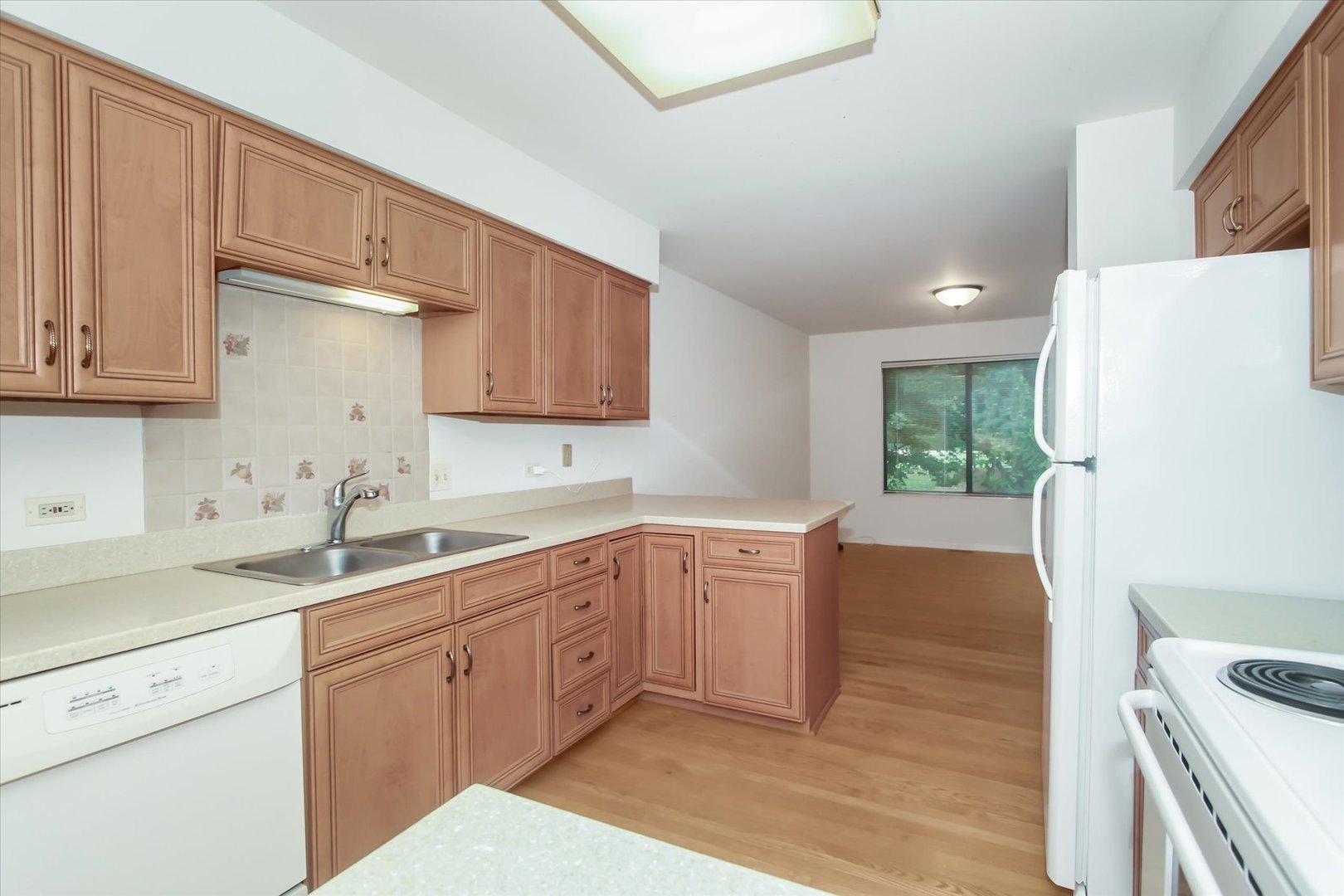 928 Longmeadow Court, Unit 1016 Barrington, IL 60010 - Photo 9 of 32 a kitchen with a sink a refrigerator and cabinets