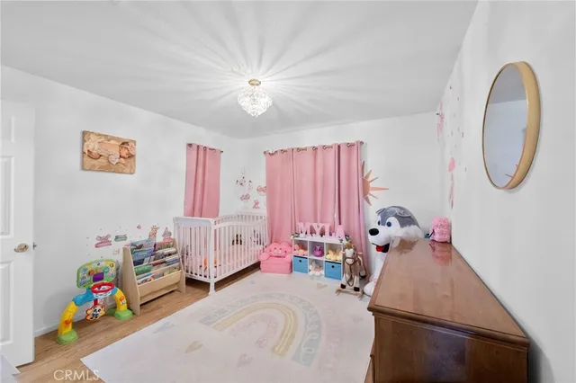 a bedroom with a bed chandelier and a window