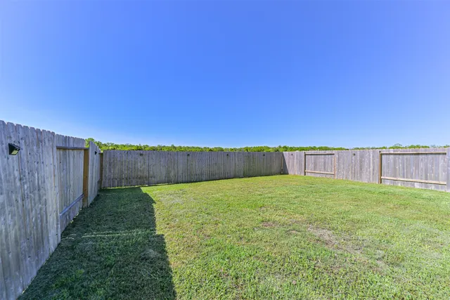 a view of a yard with wooden fence