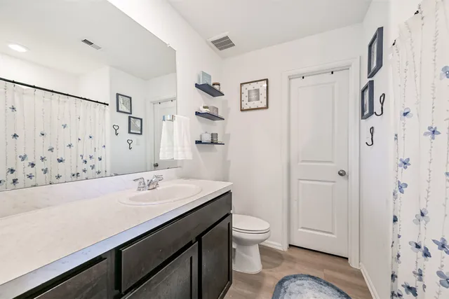 a bathroom with a sink toilet double vanity and shower