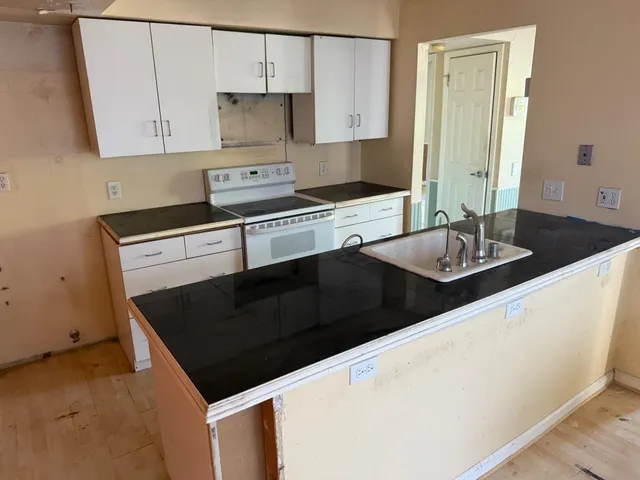 a kitchen with granite countertop a stove and a sink