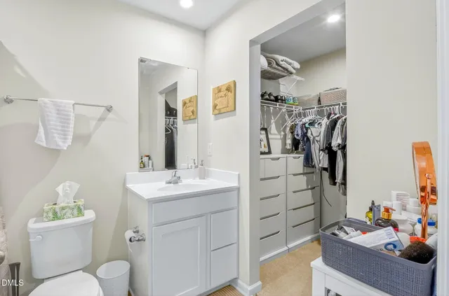 a bathroom with a sink vanity mirror and toilet