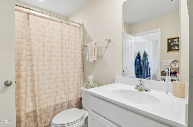 a bathroom with a sink a toilet and shower curtain