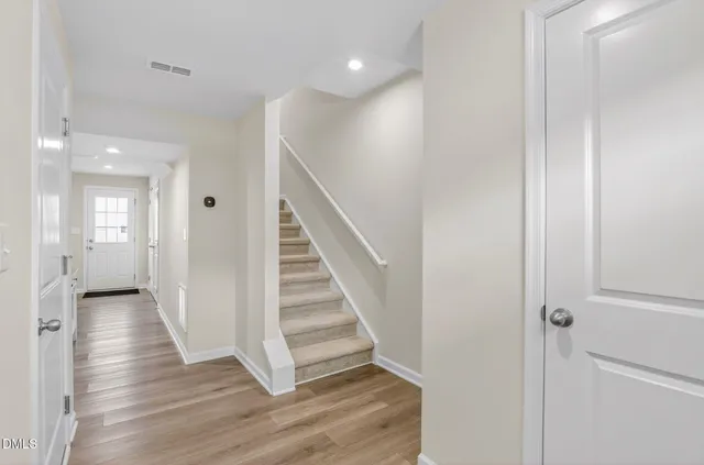 a view of a hallway with wooden floor and staircase