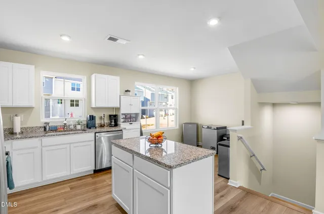 a kitchen with granite countertop a sink and cabinets
