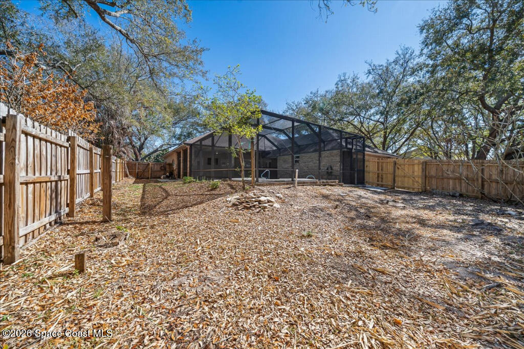 35 River Ridge Drive Rockledge, FL 32955 - Photo 33 of 48 a backyard of a house with large trees and wooden fence