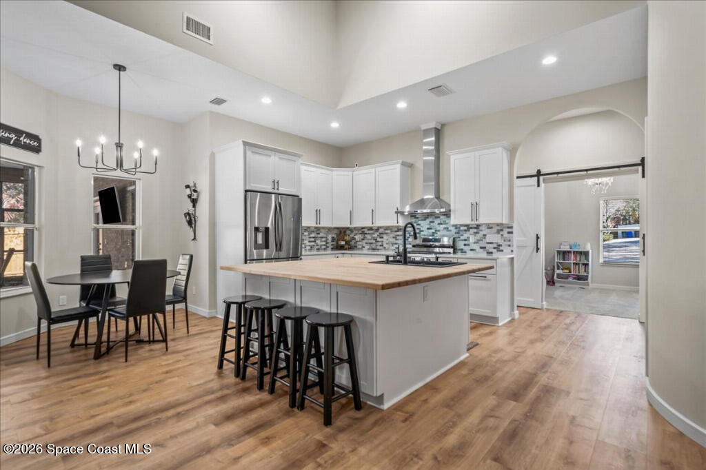 35 River Ridge Drive Rockledge, FL 32955 - Photo 8 of 48 a kitchen with stainless steel appliances kitchen island granite countertop a refrigerator a stove a sink a dining table and chairs with wooden floor