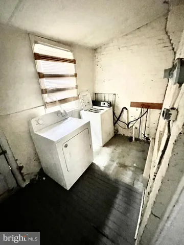 a view of washer and dryer with bathroom in the background