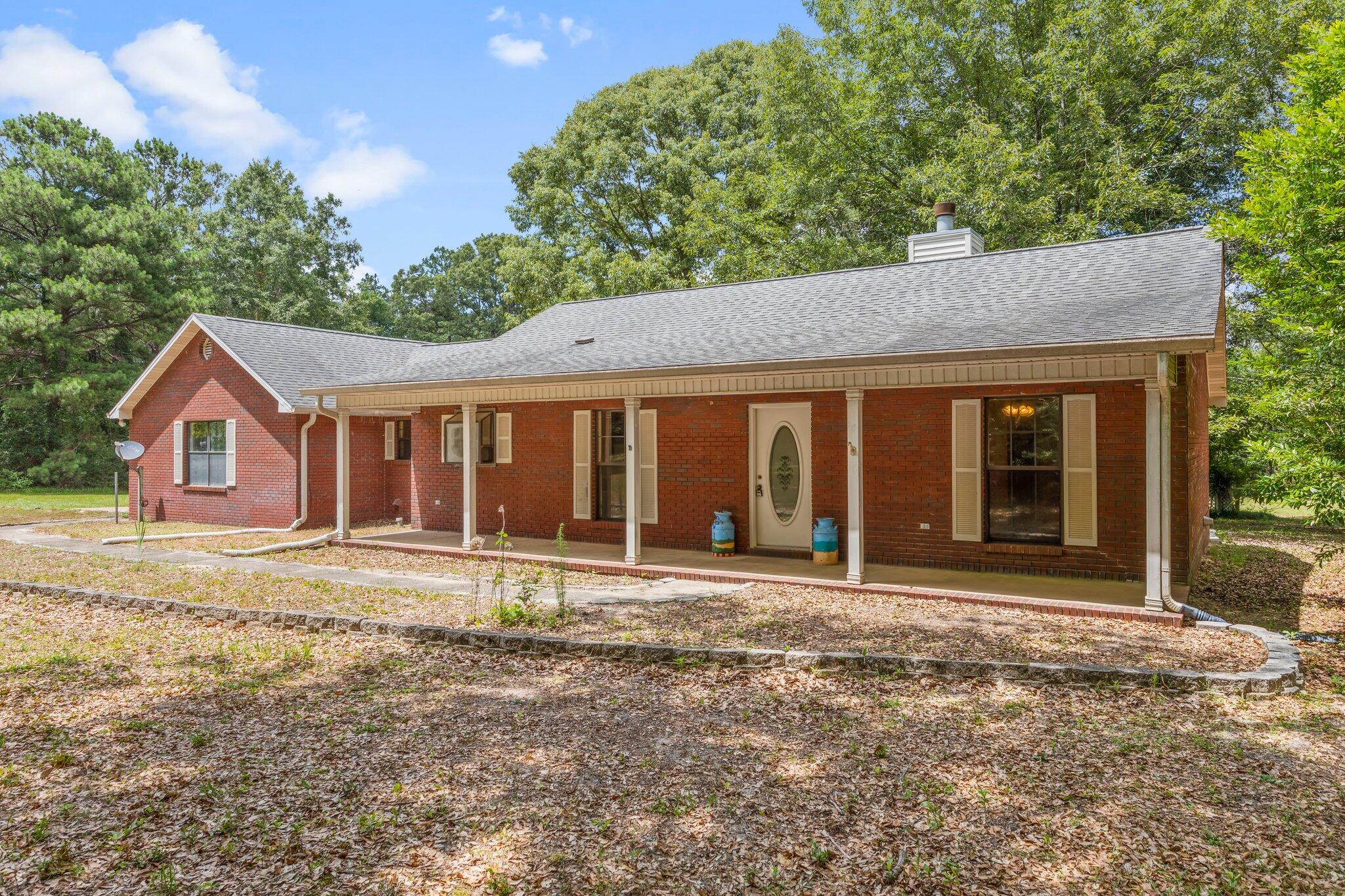 6709 Old River Road Baker, FL 32531 - Photo 1 of 43 a front view of a house with a garden