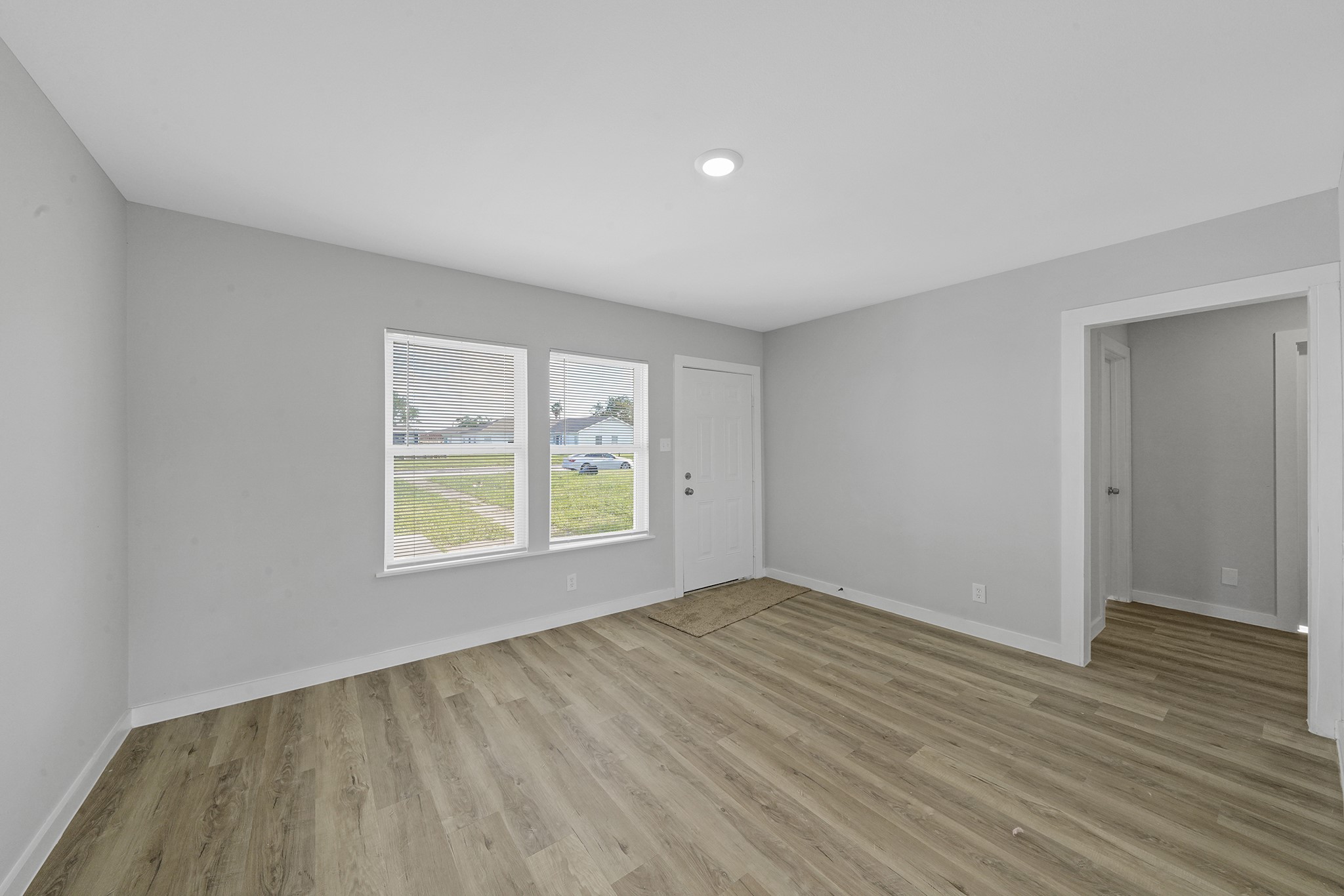 1753 West 6th Street Freeport, TX 77541 - Photo 14 of 20 an empty room with wooden floor and windows