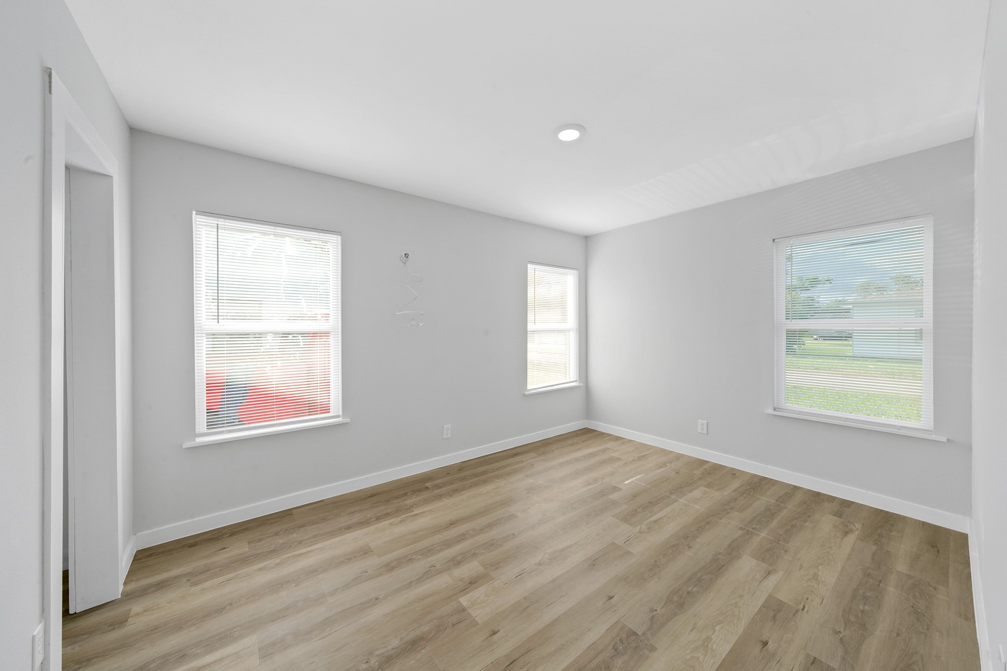 1753 West 6th Street Freeport, TX 77541 - Photo 4 of 20 a view of an empty room with wooden floor and a window