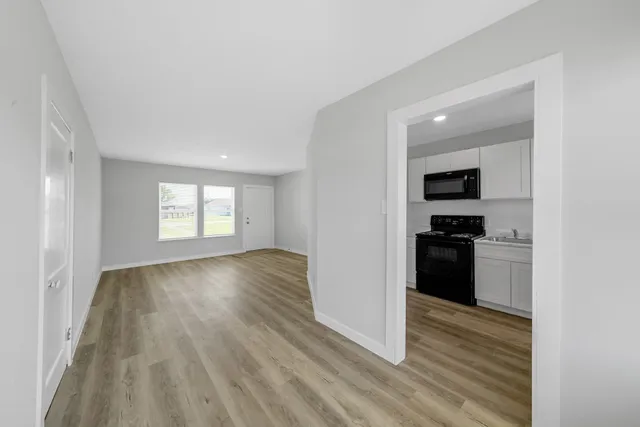 a view of a kitchen and an entryway with wooden floor