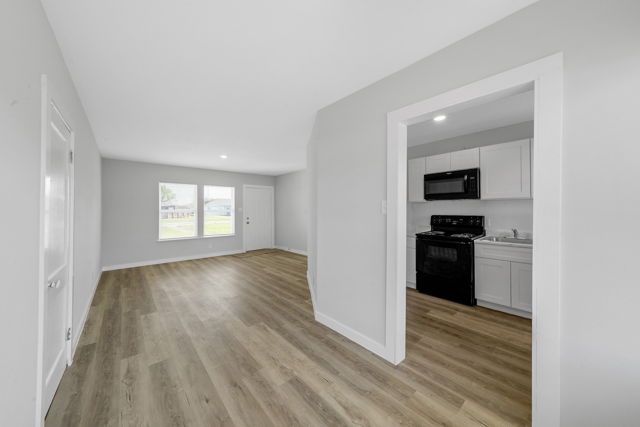 1753 West 6th Street Freeport, TX 77541 - Photo 6 of 20 a view of a kitchen and an entryway with wooden floor