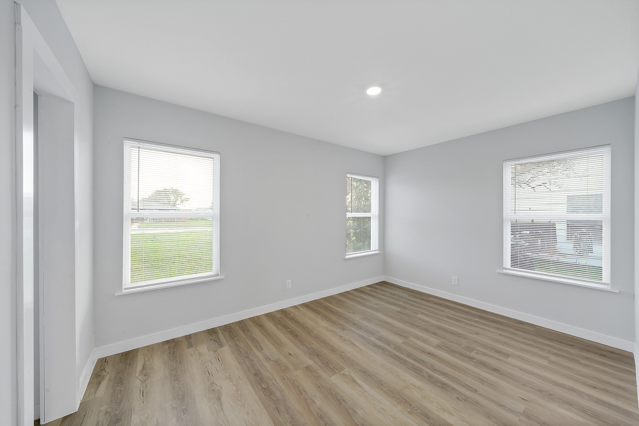 1753 West 6th Street Freeport, TX 77541 - Photo 10 of 20 a view of an empty room with wooden floor and a window