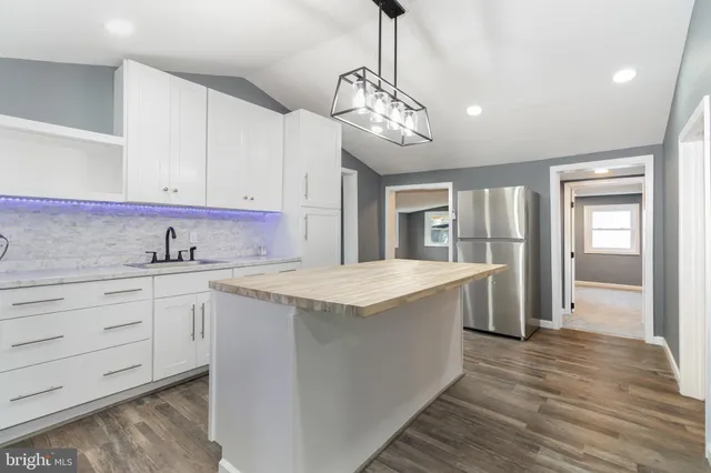 a kitchen with stainless steel appliances granite countertop a sink and dishwasher with white cabinets