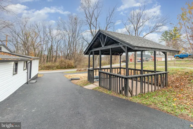 a view of backyard with small cabin and wooden fence